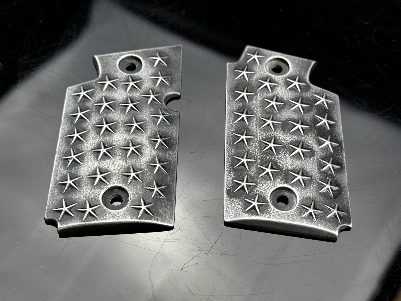 Sig P938 grip panels side-by-side comparison: factory piece on the left, AV8 restoration on the right — both in distressed silver-over-black star pattern Cerakote